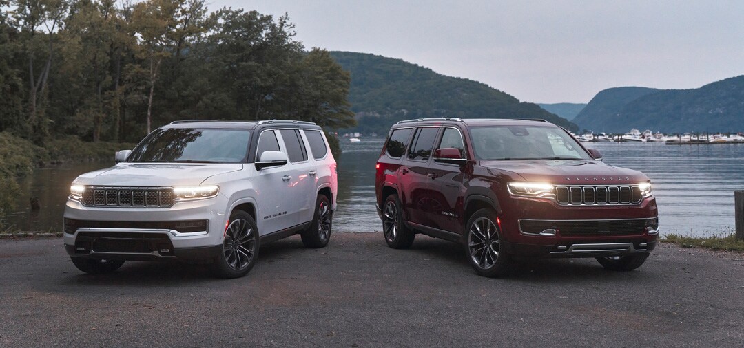 vue des Jeep Grand Wagoneer 2022 (gauche) et Wagoneer (droite) stationnés proche d'un lac