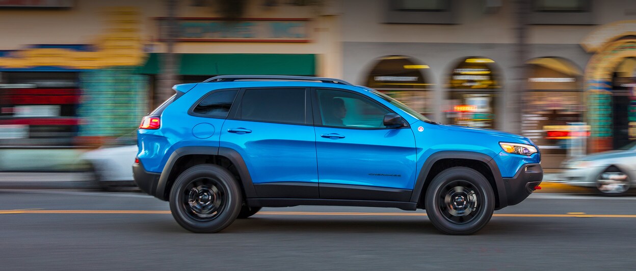 2020 Jeep Cherokee blue driving in city 2020 Jeep Cherokee blue driving in city