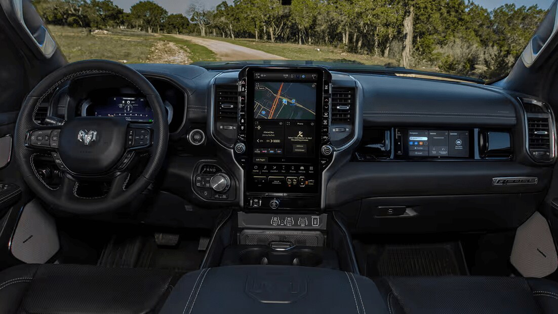 Learn about the specs & features of the 2025 Ram 1500 Interior of Ram 1500 showing the steering wheel, touchscreen, and console controls