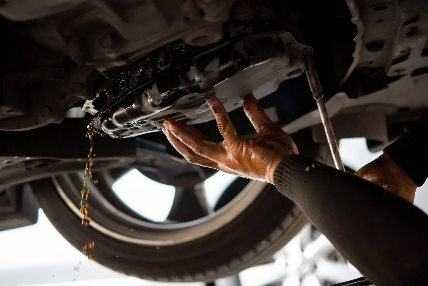 Car mechanic drain the old automatic transmission fluid (ATF)