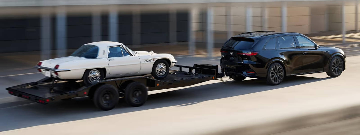 2025 Mazda CX-70 towing a classic car on a trailer