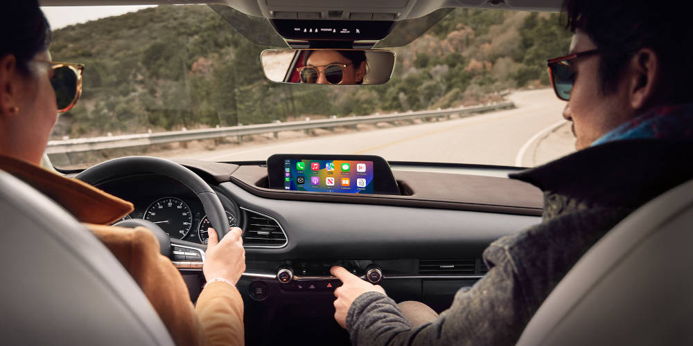 Man using smartphone integration in a Mazda