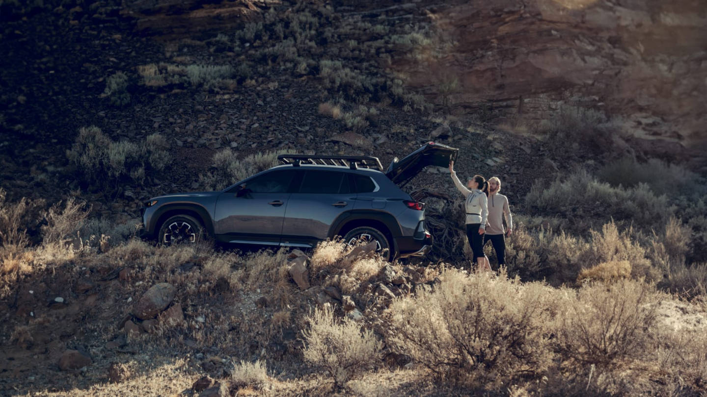 2025-mazda-cx-50-liftgate.jpg 2025 Mazda CX-50 Hybrid MPG parked in the mountains