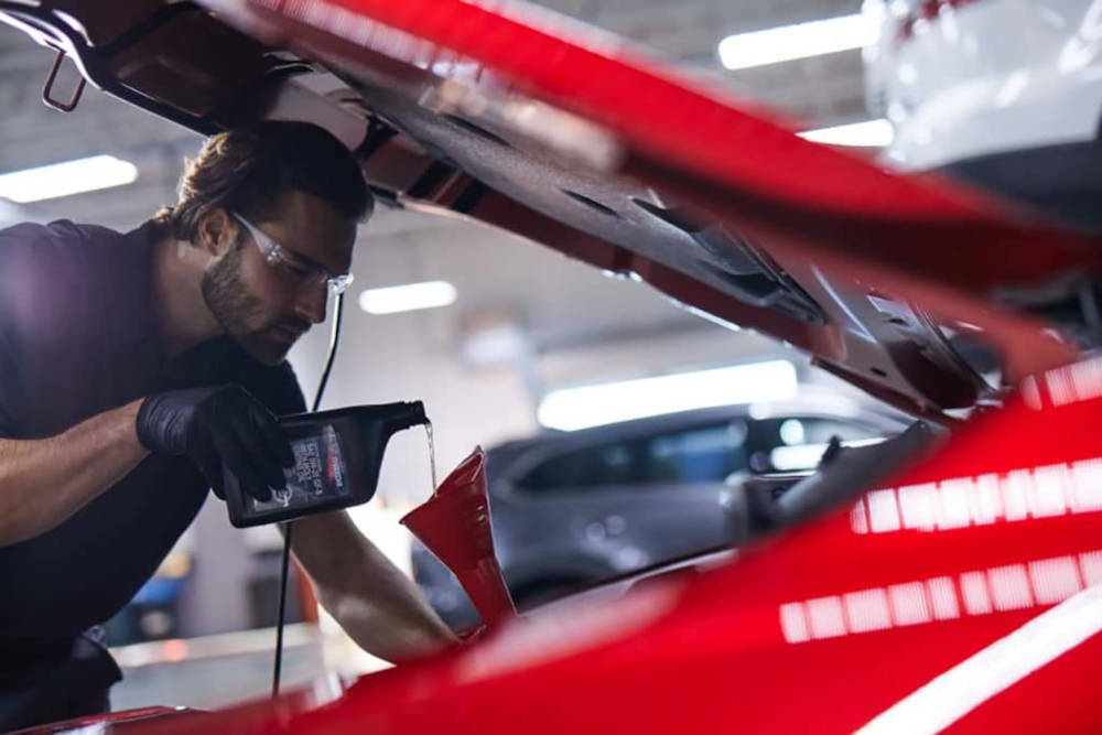 Man pouring oil into an Engine