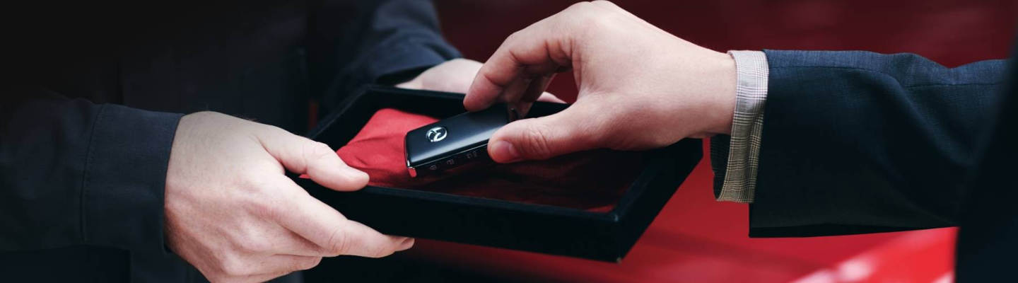 Mazda key fob being handed to a new customer in a gift box