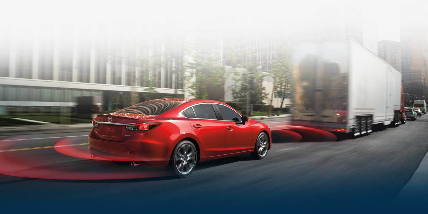 Mazda driving behind a truck with i-ACTIVSENSE
