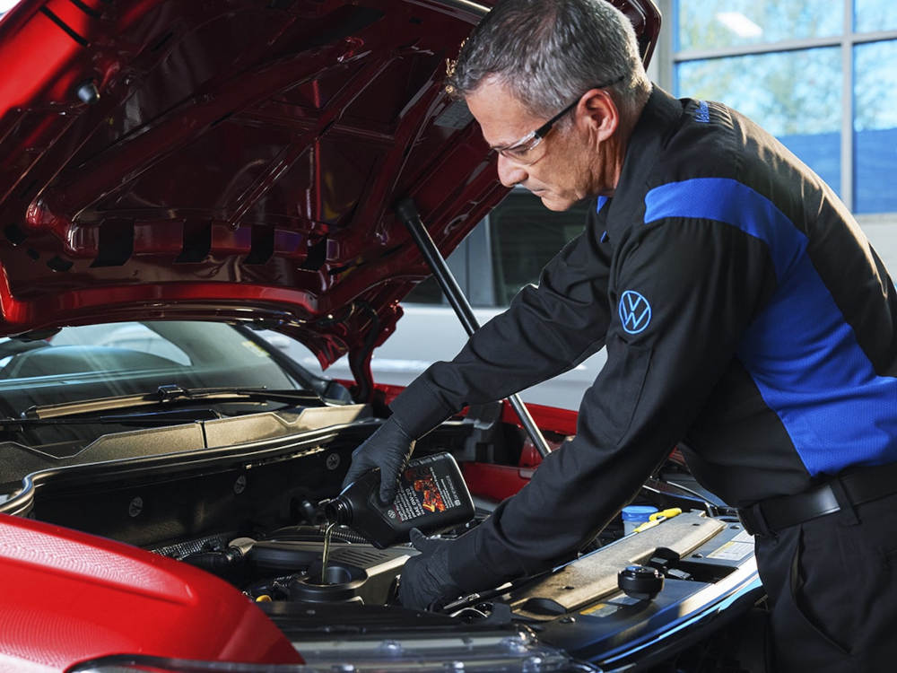 mechanic changing oil on a Volkswagen