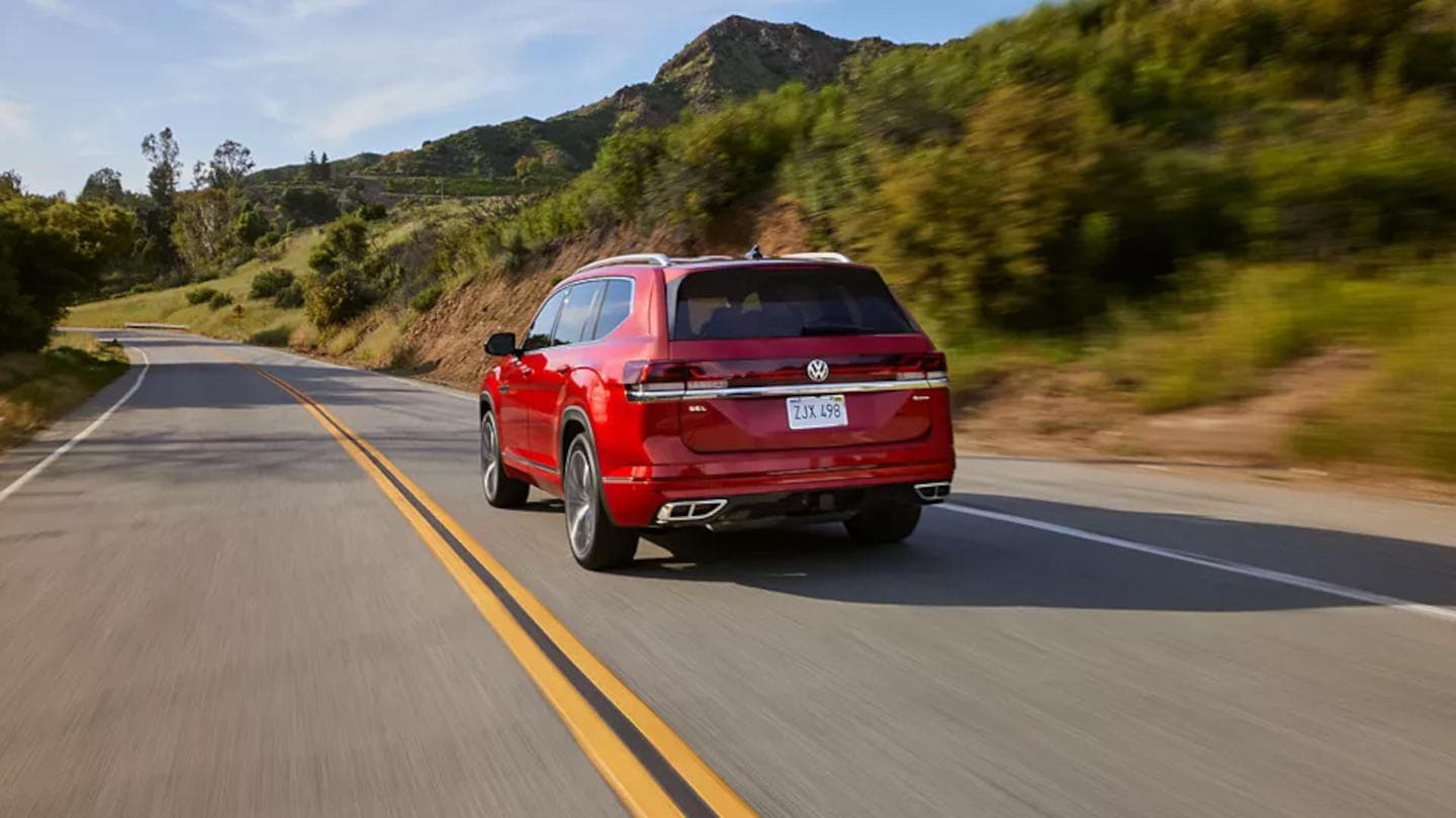 2025 Volkswagen Atlas driving around a corner rear view