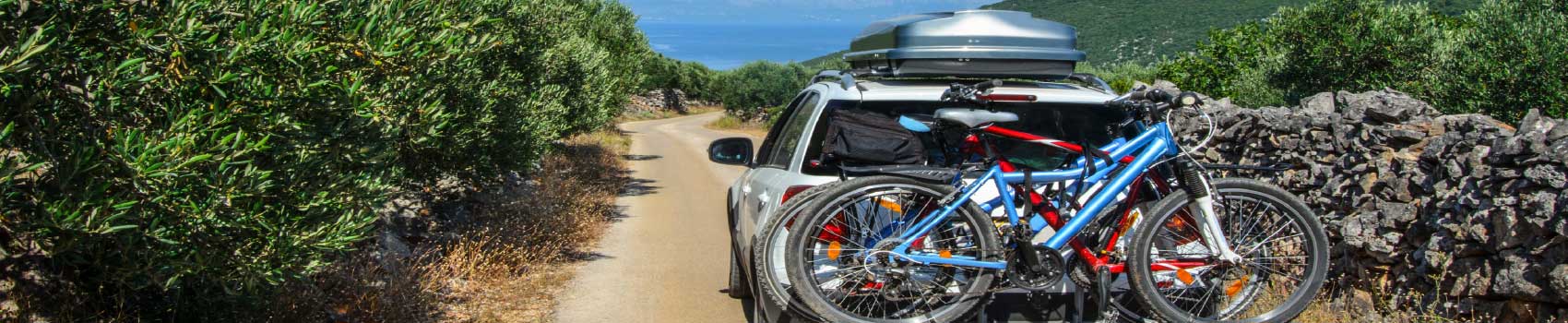 family-road-trip-car-packed.jpg Family packing their car for a summer road trip with bikes and roof box.