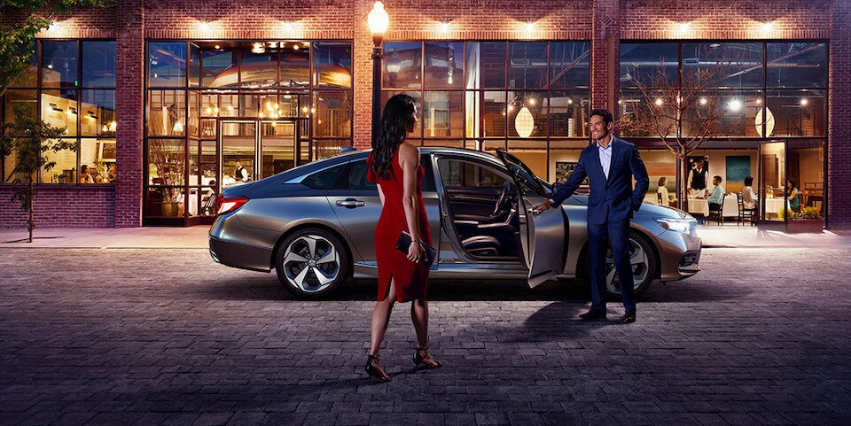 Man holding Honda door for well dressed woman at night.jpeg