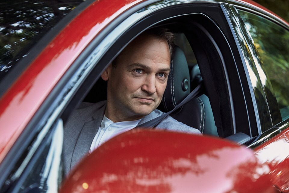 Man sitting in driver seat of red Jaguar.jpeg