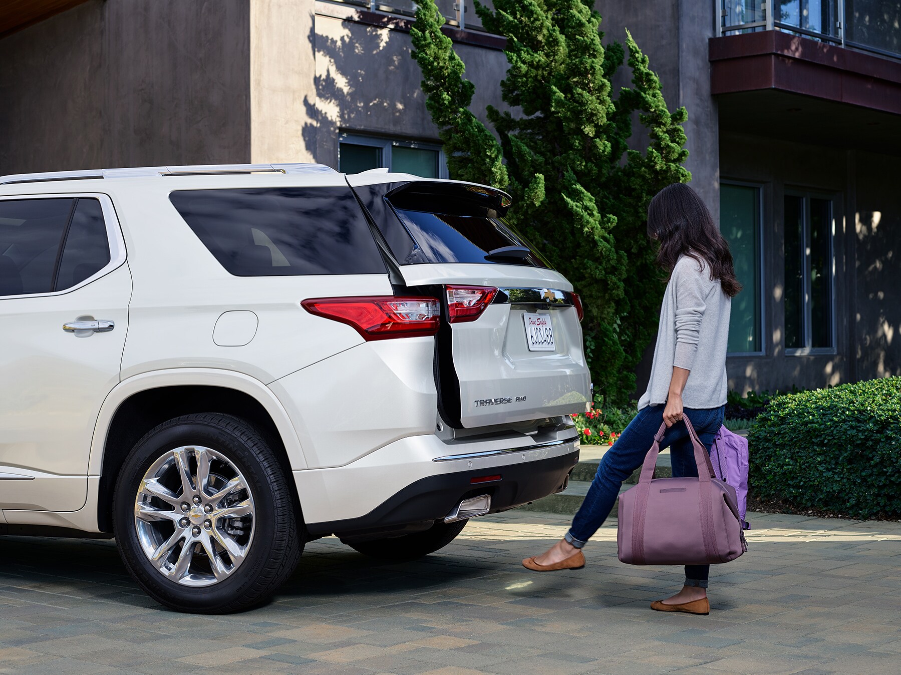 Chevrolet of New Bern is a Car Dealership in New Bern near Pollocksville NC | Woman opening liftgate of 2020 Chevrolet Traverse