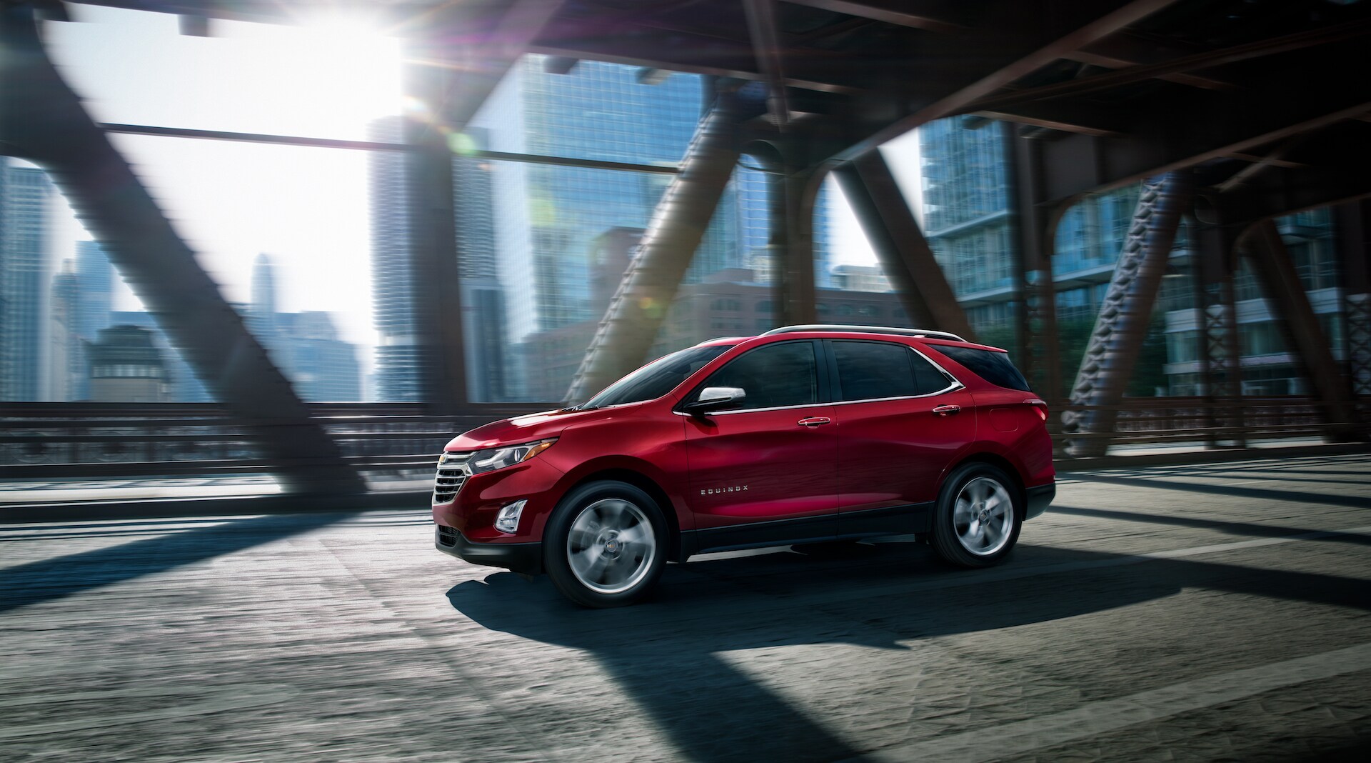 Chevrolet of New Bern is a Car Dealership in New Bern near Pollocksville NC | Red 2020 Chevrolet Equinox driving on bridge