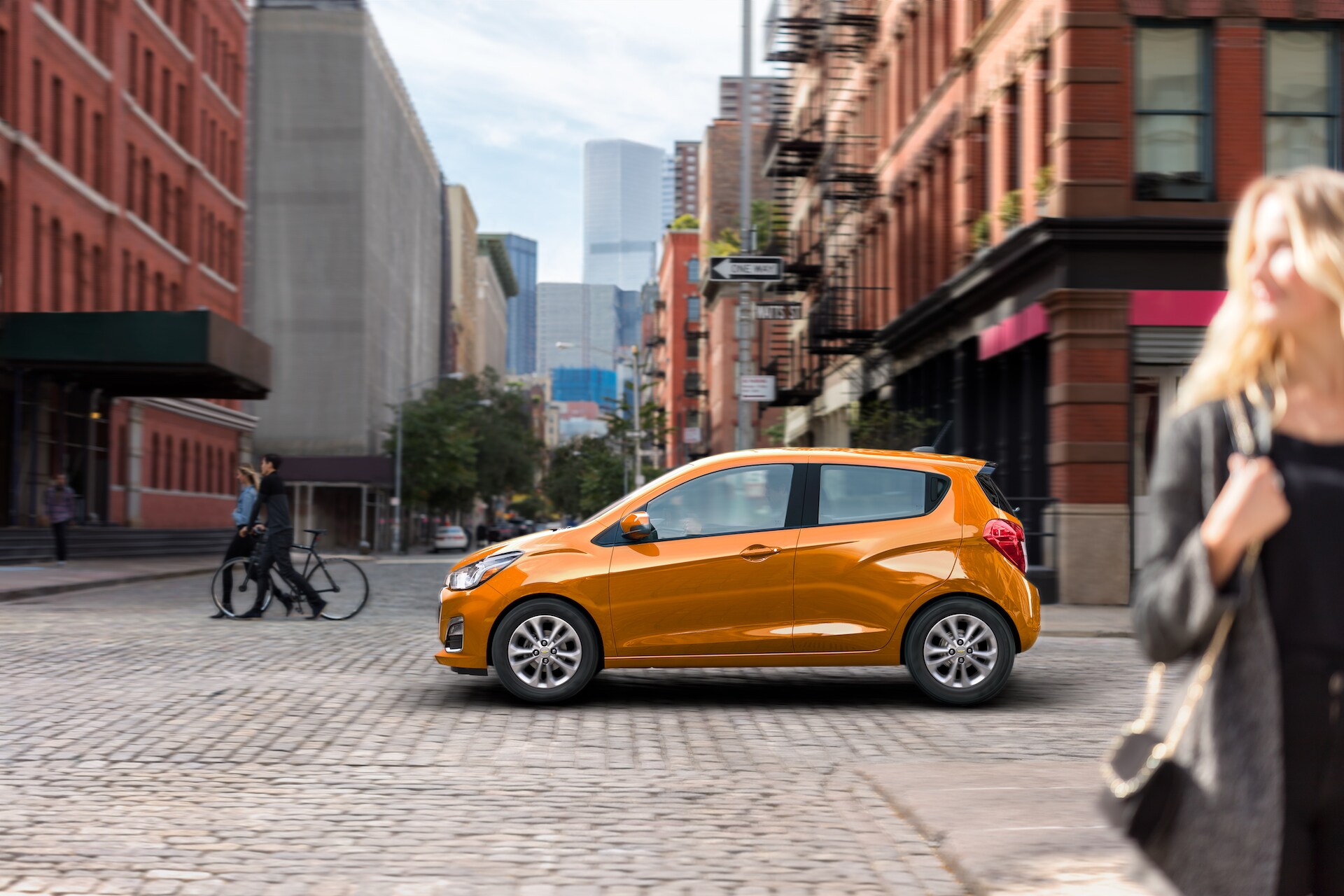 Chevrolet of New Bern is a Car Dealership in New Bern near Grantsboro NC | Orange 2020 Chevrolet Spark parked on cobblestone street