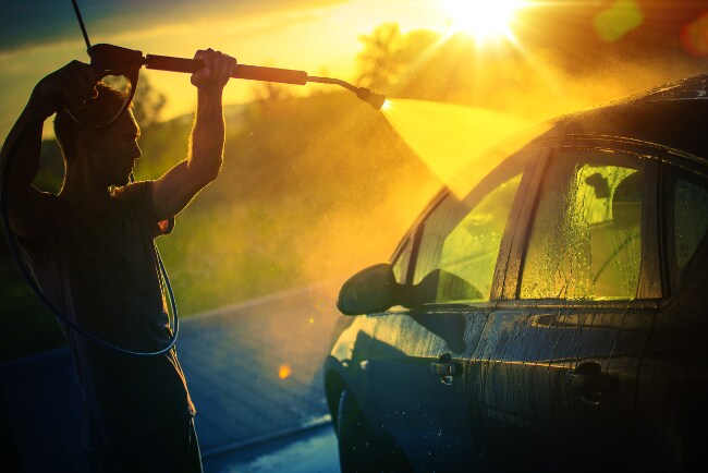 man washes car