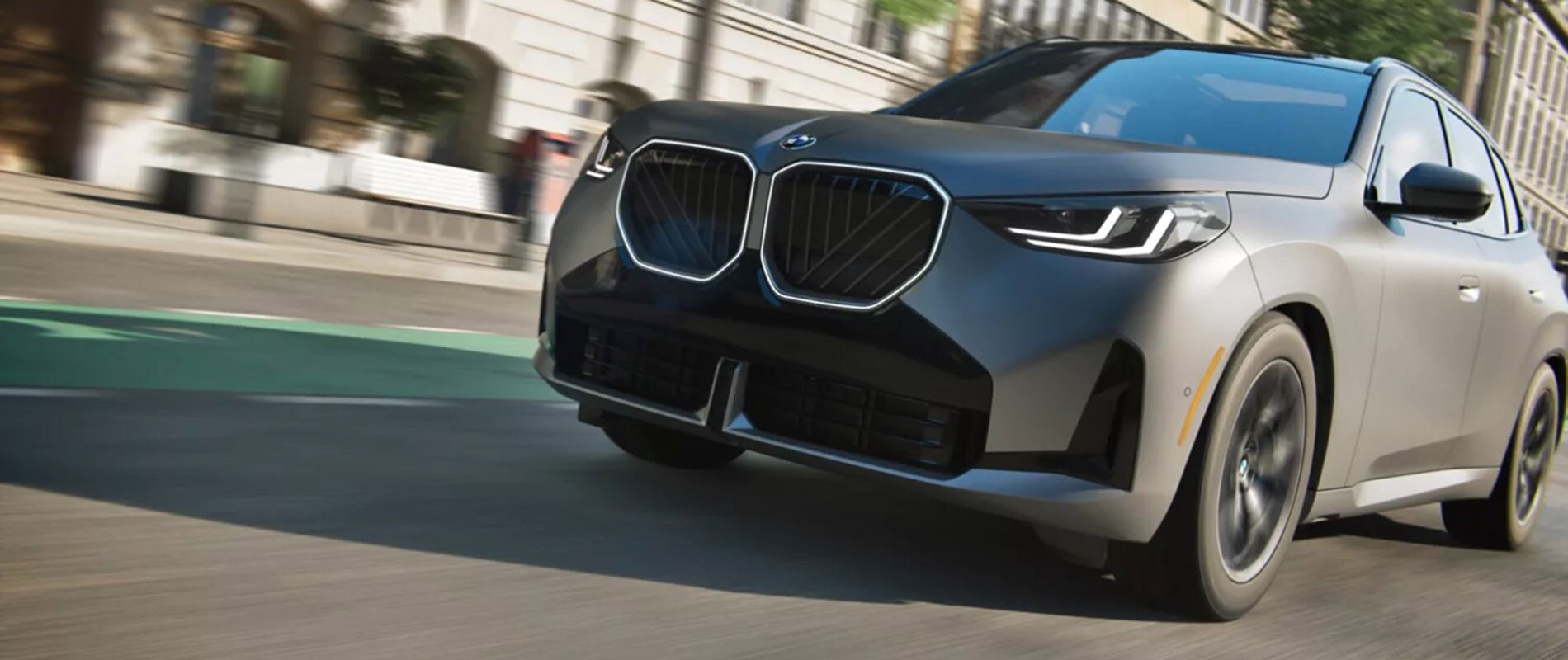 2026 BMW X3 Trim Comparison Front-view of a 2026 BMW X3 driving downtown