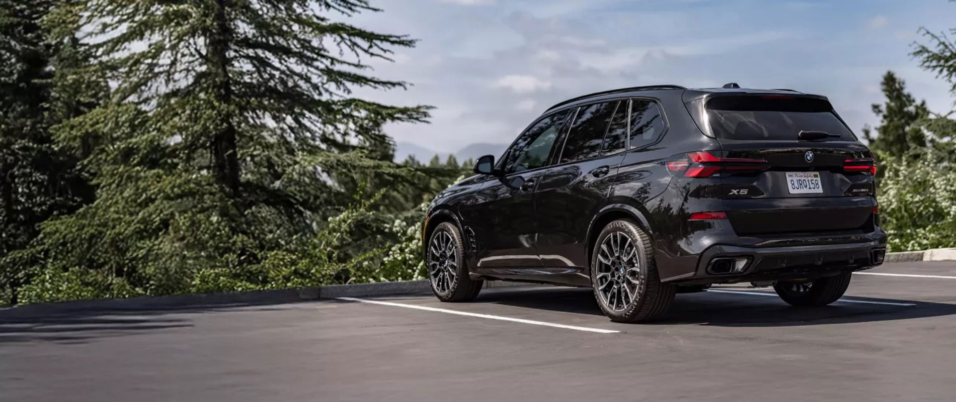 2026 BMW X5 Trim Comparison 2026 BMW X5 parked in a parking lot by woods