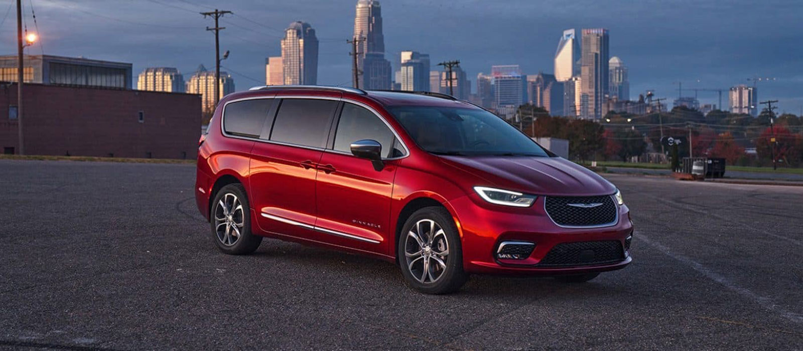 2026 Chrysler Pacifica Trim Comparison Red 2026 Chrysler Pacifica parked before a city landscape