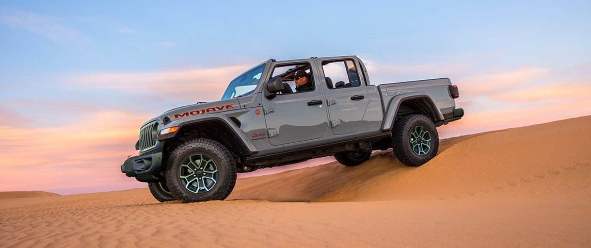 2026 CDJR Trim Comparison Jeep Gladiator parked on a sand dune