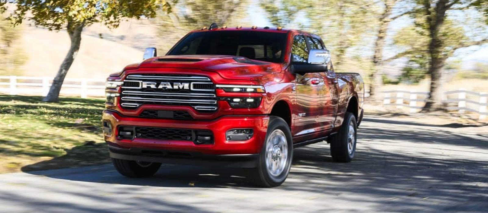 2026 Ram 2500 Trim Comparison A red 2026 RAM 2500 driving around curve
