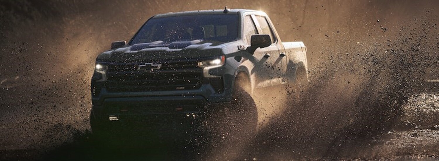 2026 Chevrolet Silverado 1500 Trim Comparison 2026 Chevy Silverado 1500 driving through mud