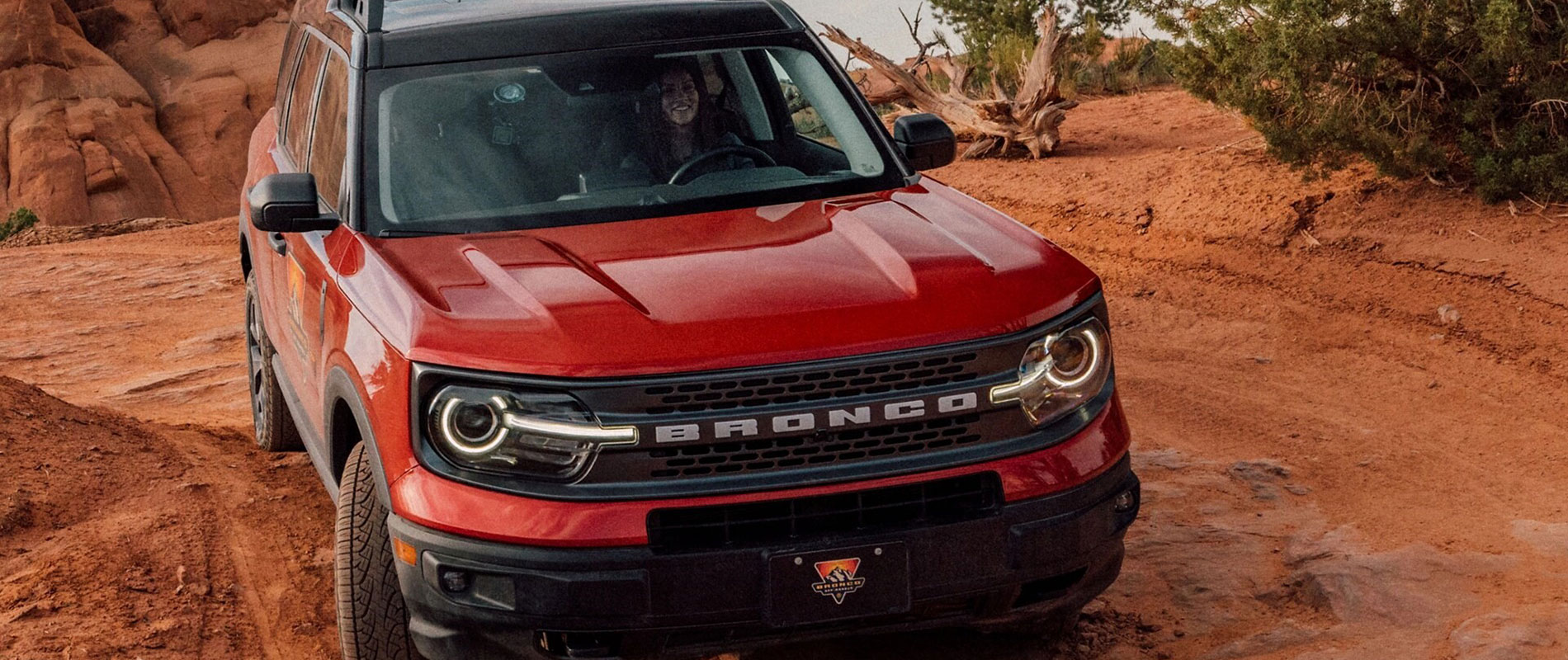 2025 Ford Bronco Sport Trim Comparison Smiling woman driving a red 2025 Ford Bronco Sport