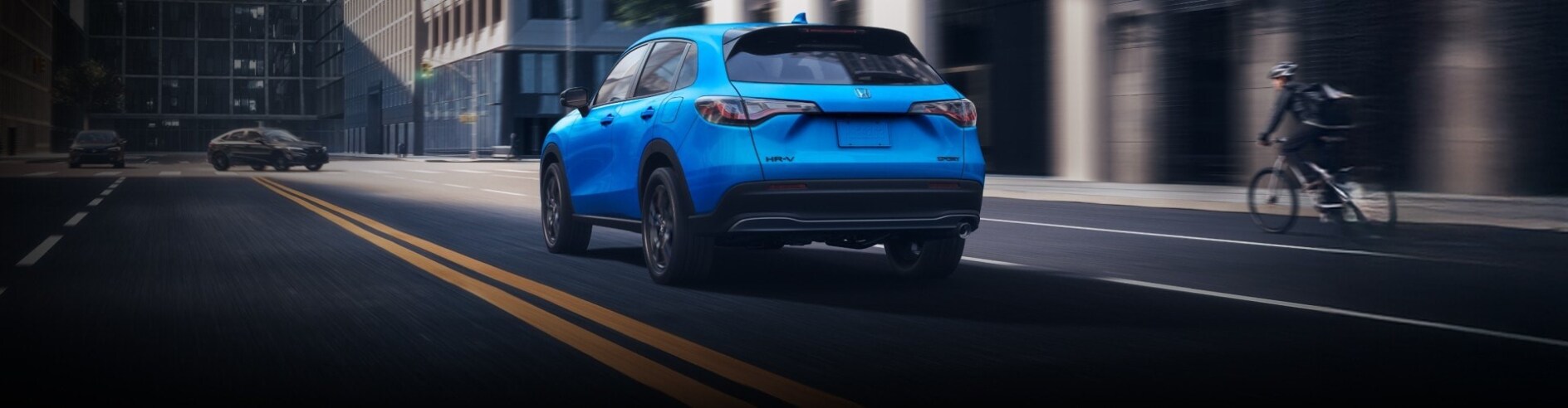 New 2026 Honda HR-V driving next to a cyclist New 2026 Honda HR-V driving next to a cyclist