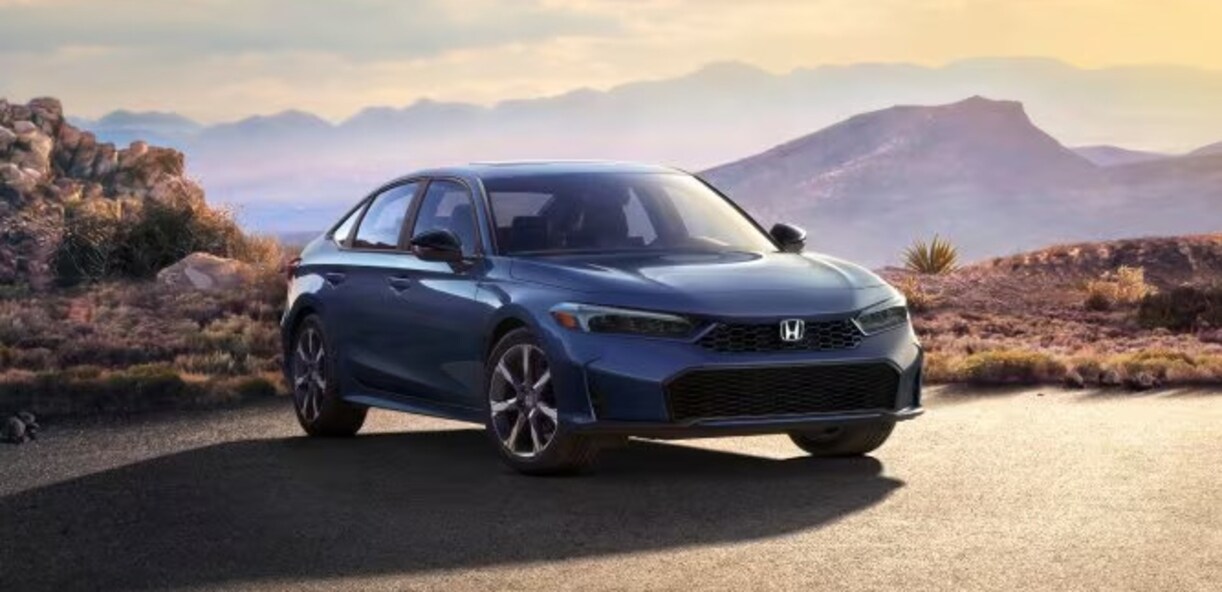 A blue 2026 Honda Civic sedan parked on a desert ledge with sunset mountains in the background