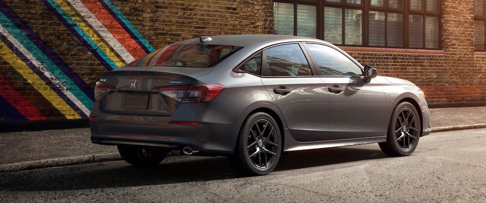 A gray 2026 Honda Civic sedan parked next to a painted brick wall A gray 2026 Honda Civic sedan parked next to a painted brick wall