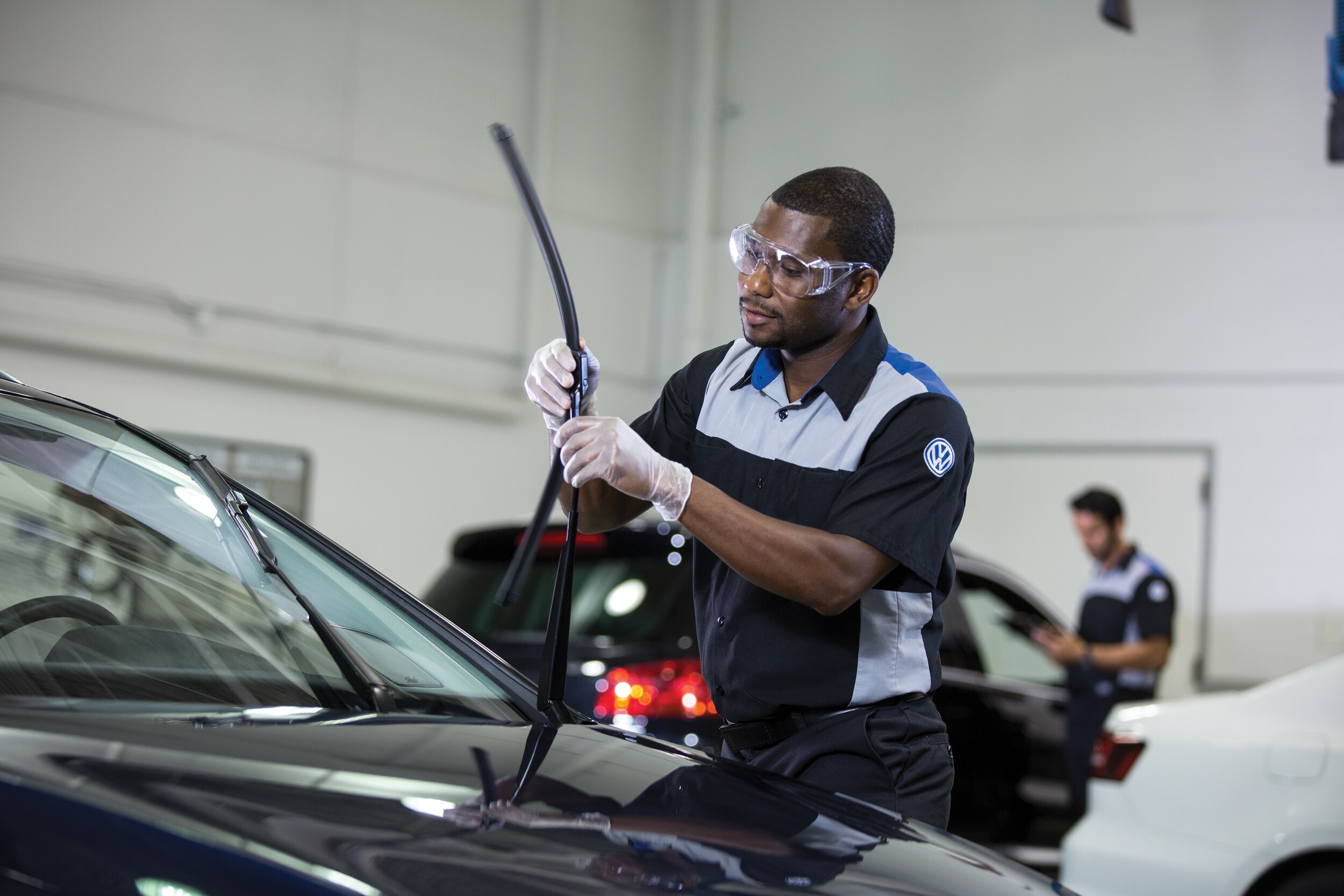volkswagen service technician replacing windshield wipers