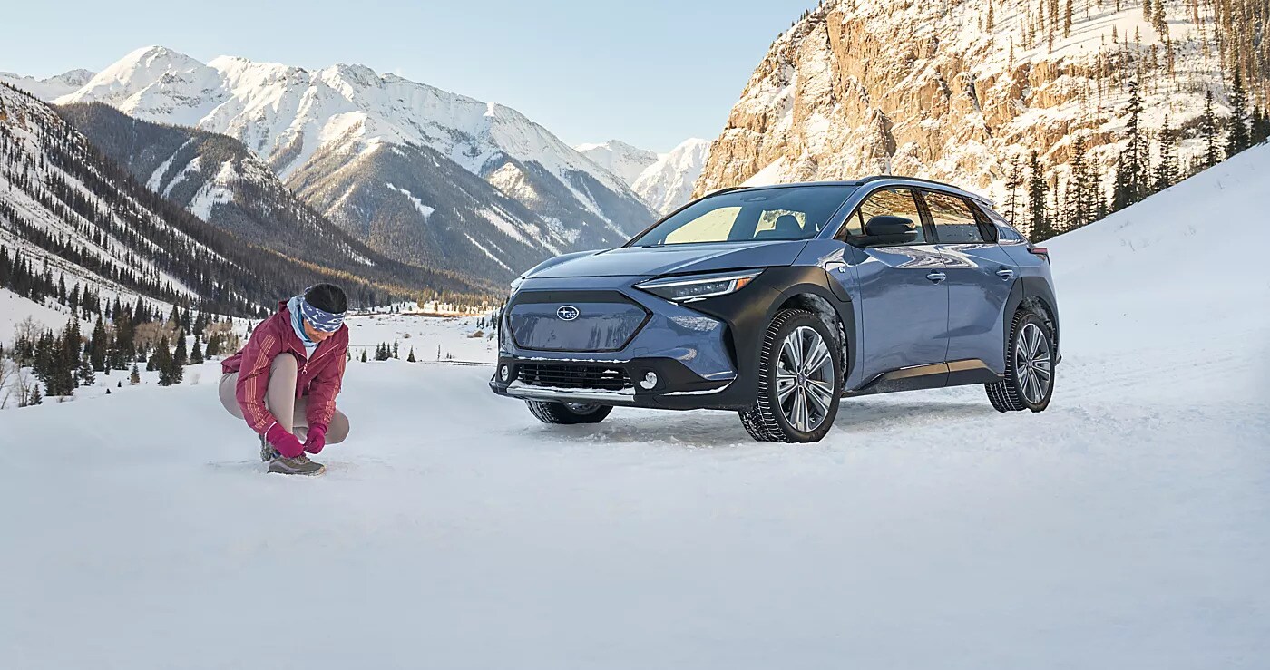 Blue Subaru Solterra electric SUV in deep mountain snow