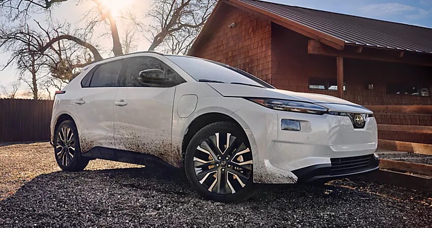 White Subaru Solterra electric SUV covered in mud after driving on rough terrain
