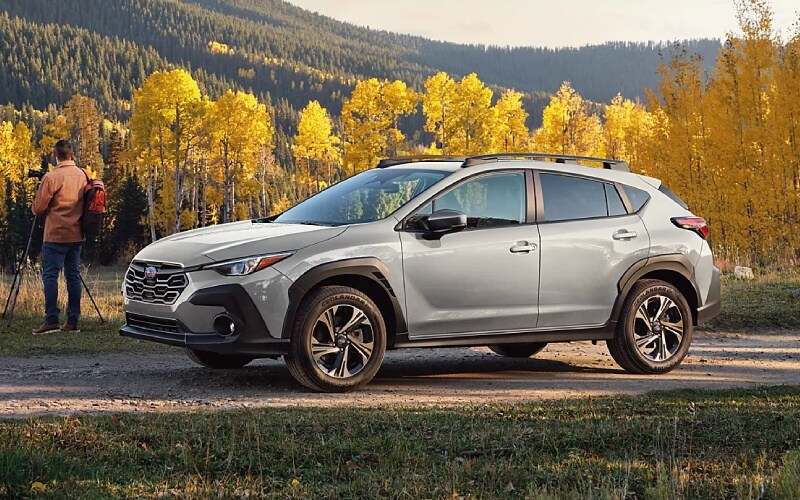 Silver Subaru Crosstrek parked near a mountain road with autumn trees