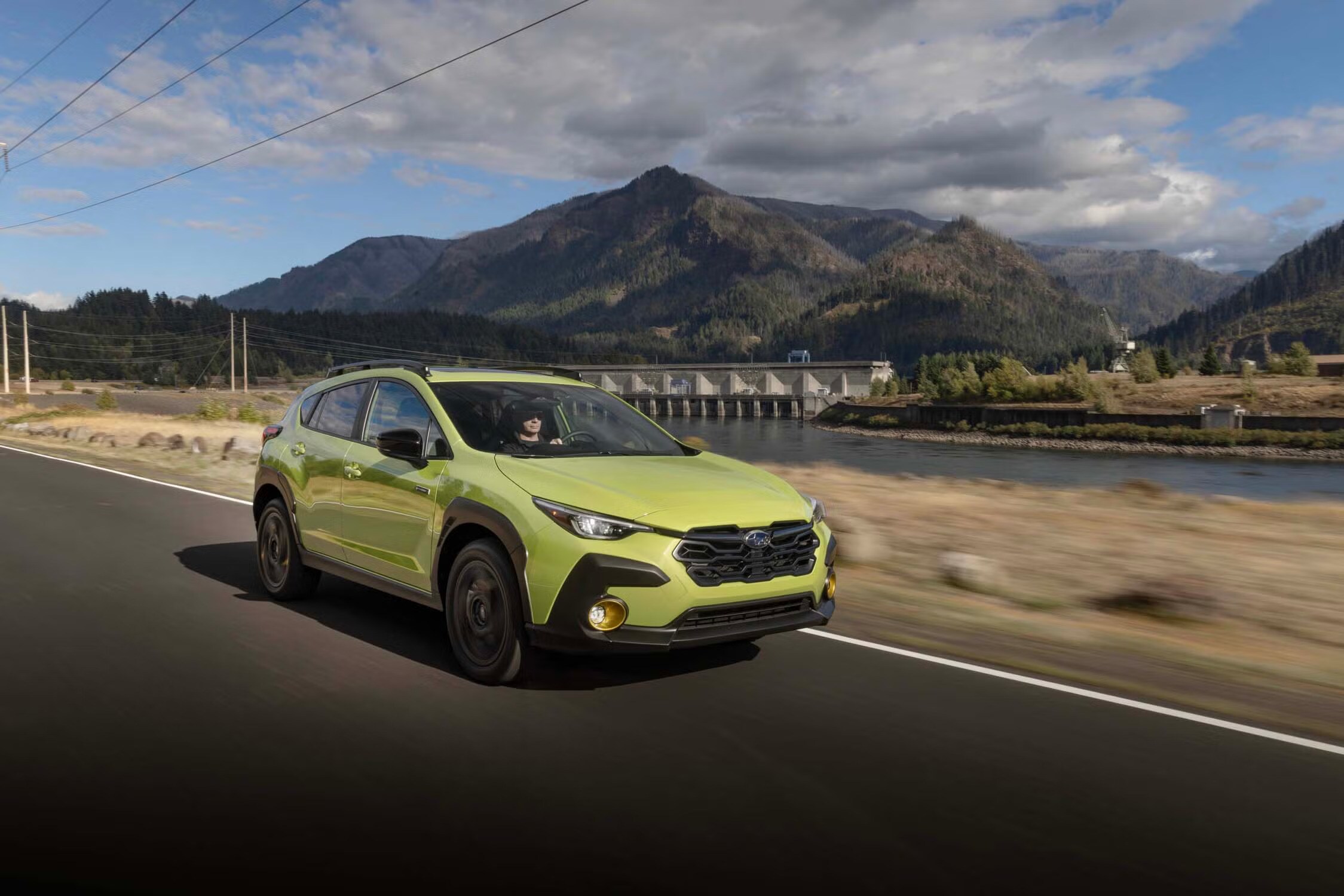 Green Subaru Crosstrek driving on a mountain road