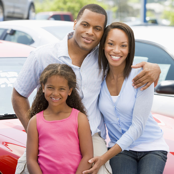 family of three at outdoor car dealership lot.jpg