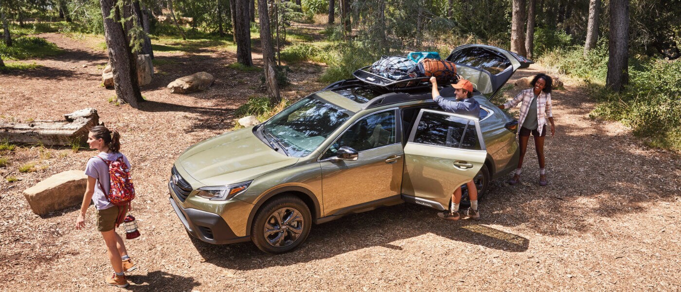 Man Packing up a 2021 Green Subaru Outback in the Forest