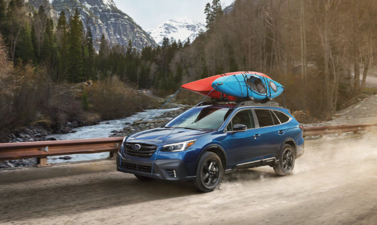 2021 Blue Subaru Outback Hauling Two Canoes on the Roof