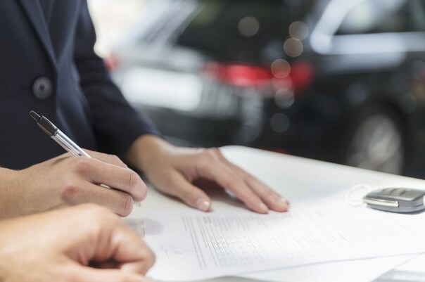 Why Finance with Cole Automotive? People sign a buy or lease a vehicle form