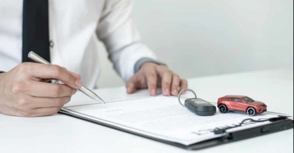 Why Finance with Cole Nissan? Person signing a finance agreement for a car