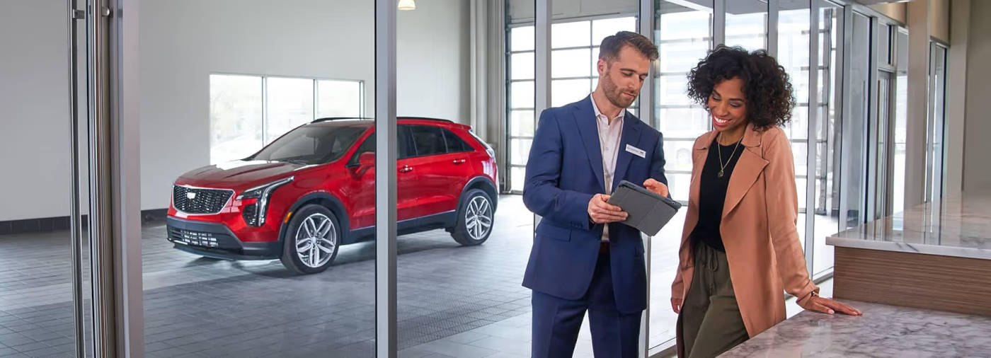 Cadillac salesman going over papers with a customer