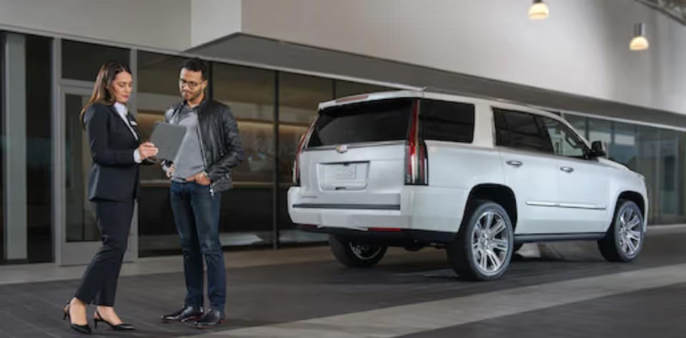 Cadillac-fiance-3.jpg Car dealer businesswoman Reviewing lease paper with a customer.