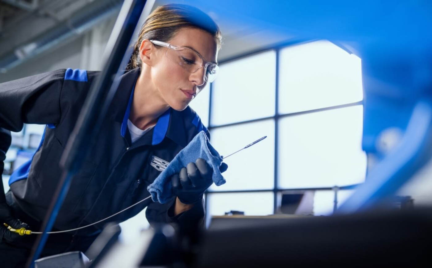 Cadillac mechanic servicing engine oil