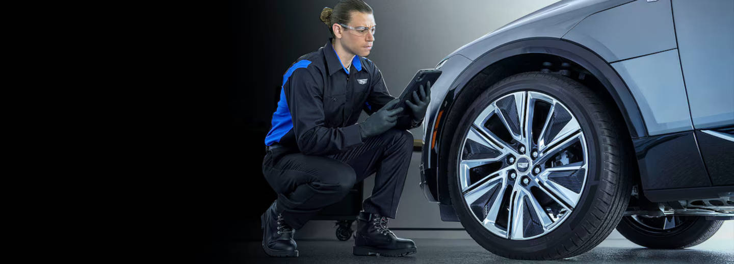 Picture of Cadillac being serviced by a technician