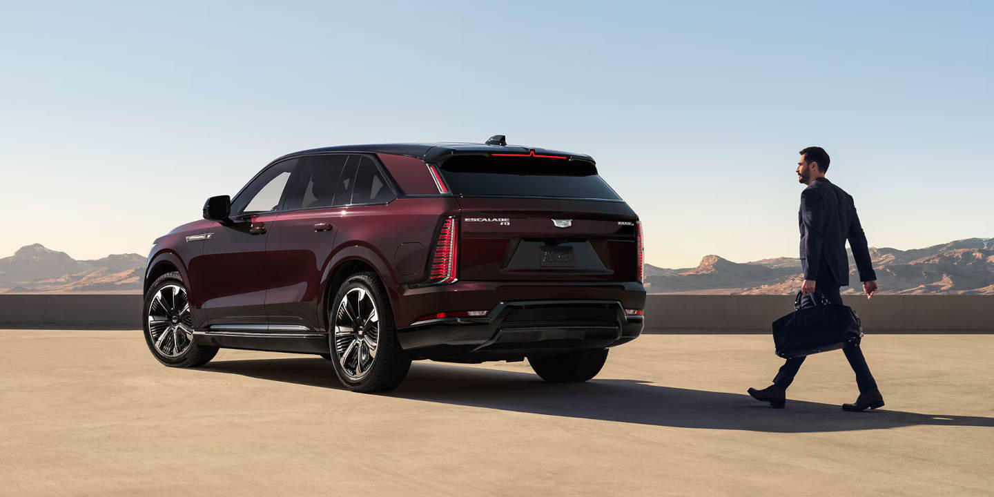 2026 Cadillac Escalade IQ parked with a business man walking up to it