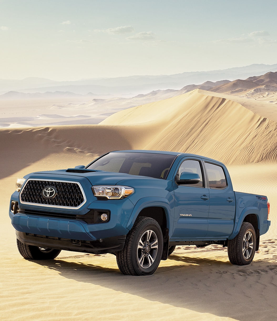TacomaInSand.jpg Blue 2019 Tacoma driving through sand dunes