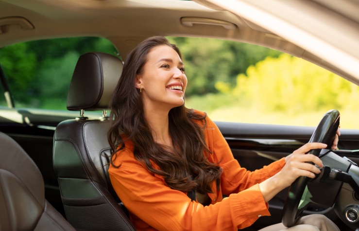 Woman happily driving her new car