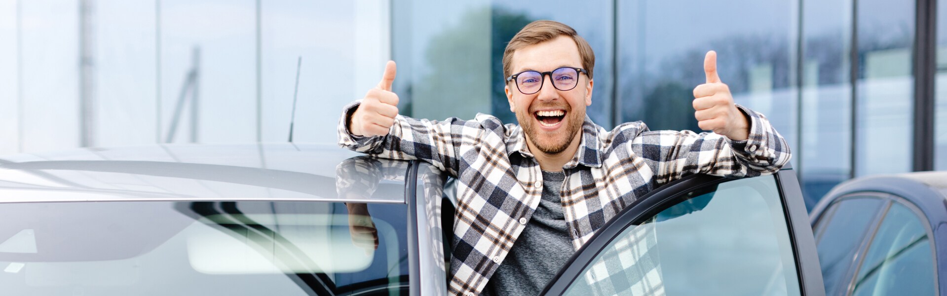Man standing outside the driver side door with two thumbs up
