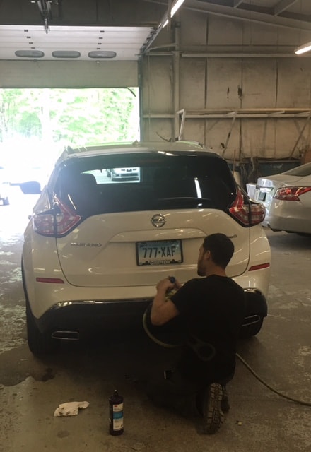 A Technician Working on a Nissan SUV auto body repair being done to a Nissan SUV