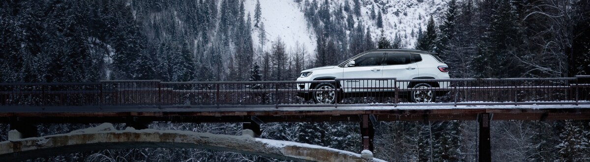 2019-Jeep-Compass-Limited-SUV-L04 (1).jpg New Jeep Compass driving over a bridge at winter