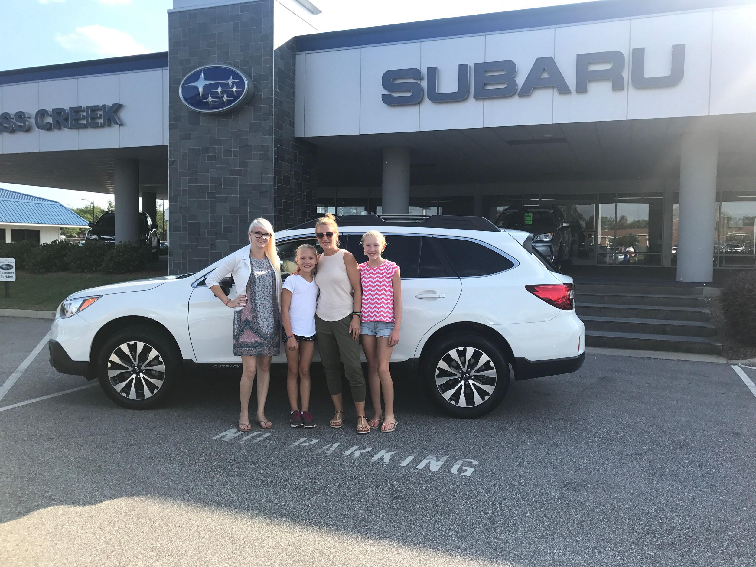 Nicole and two of her three kids with Sales Advisor Ava - in front of her first Subaru, a 2015 Outback.jpg